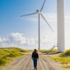 Woman walking towards a windmill at Hvide Sande, Jutland