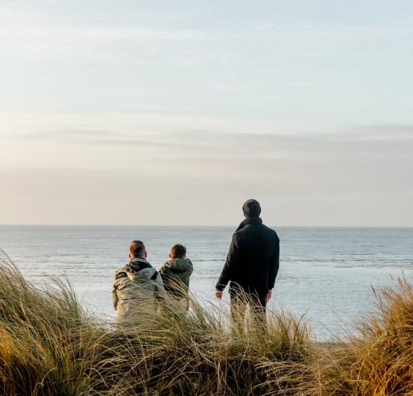 Familie ser utover havet på Blåvand strand, Vestjylland