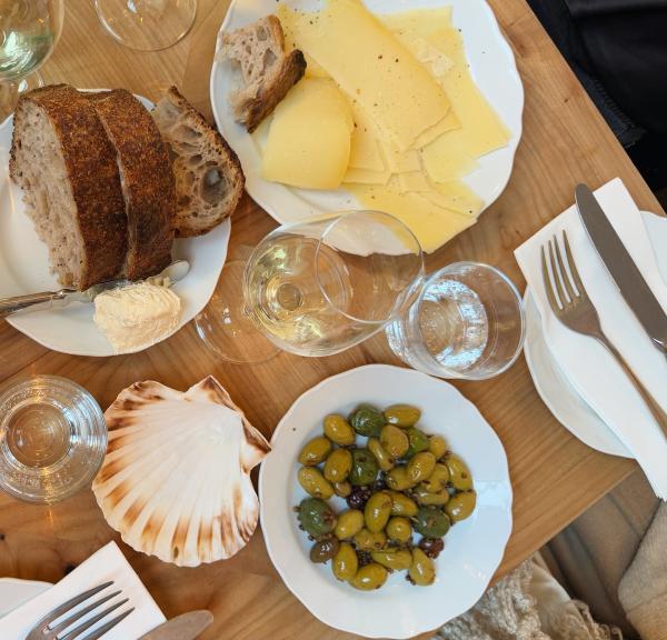 A table full of food including olives, a seashell, cheese and bread from Apollo Bar Copenhagen